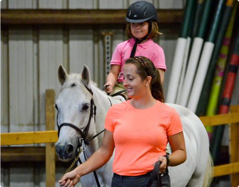 A woman and girl riding on the back of a white horse.