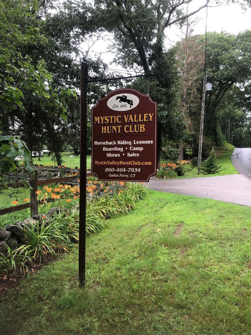 A sign in front of some bushes and trees