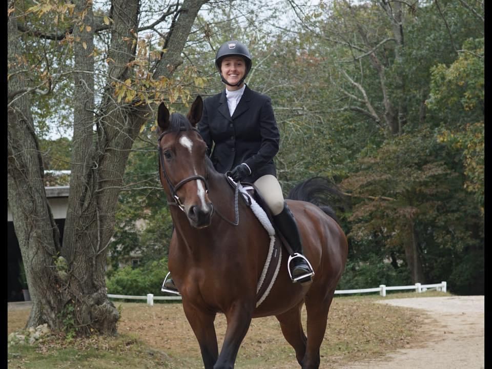 A woman riding on the back of a brown horse.