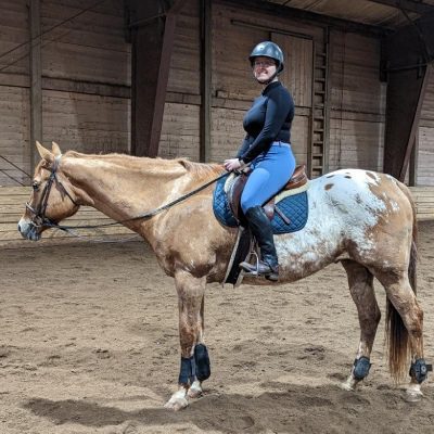 A woman riding on the back of a horse.