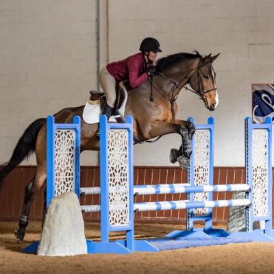 A person jumping over an obstacle on a horse.